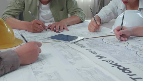 Close Up Of Group Of Asian Engineers Drawing Building Construction At The Office