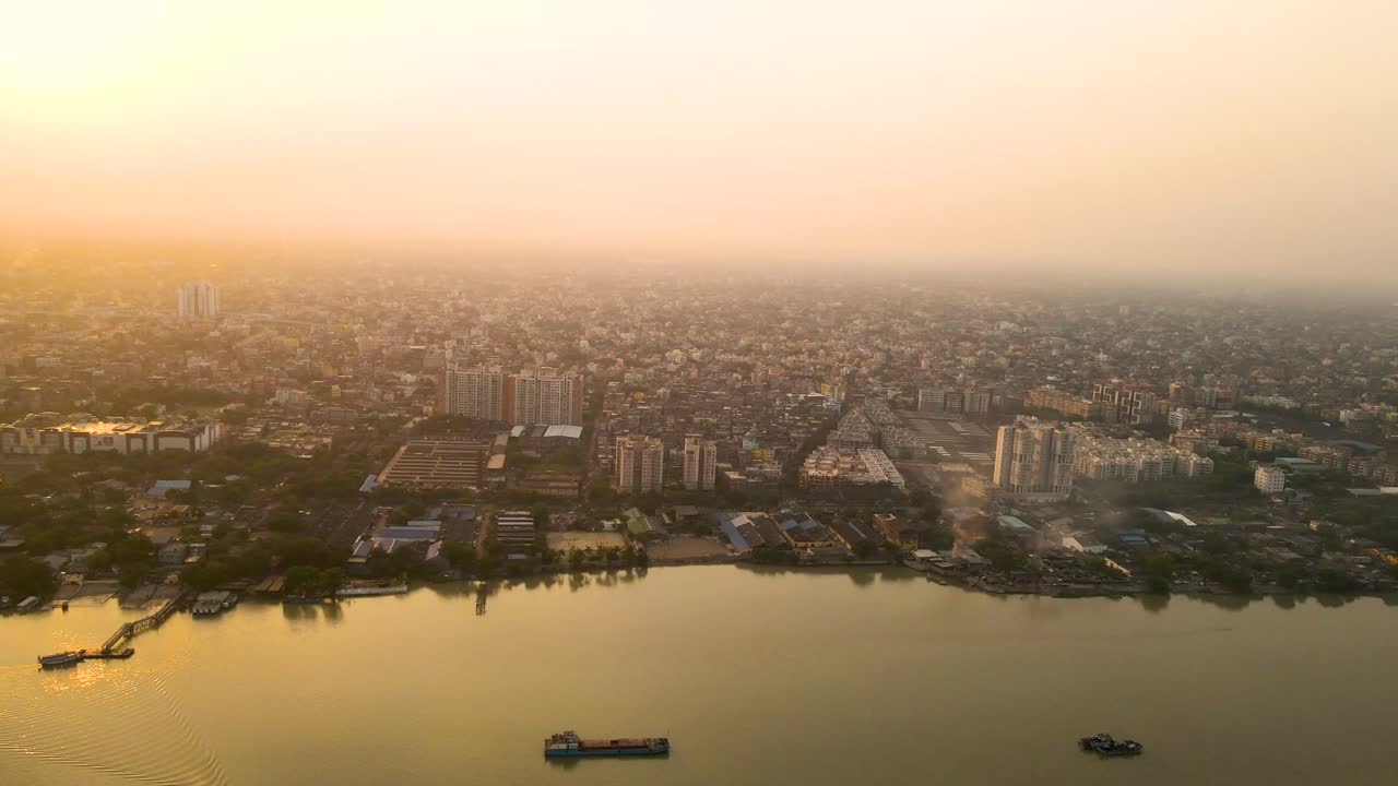 Aerial drone shot of Vidyasagar Bridge in Kolkata, bathed in soft sunset hues and city lights beginning to shine.