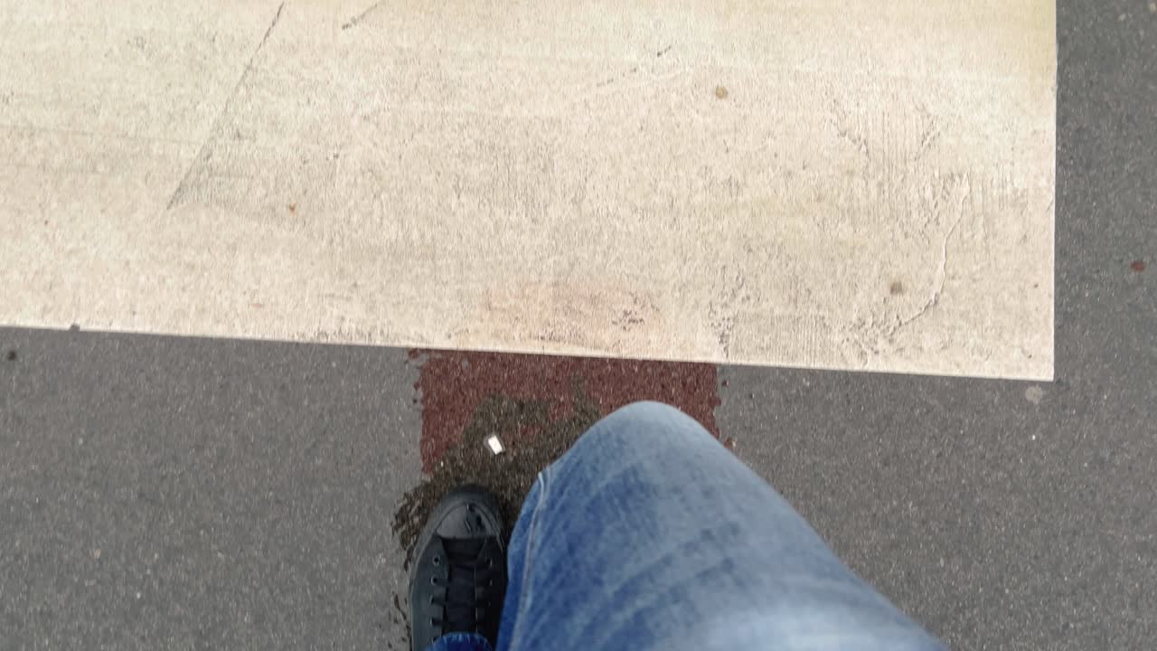 Walking over pedestrian zebra crossing on a rainy day, pov shot