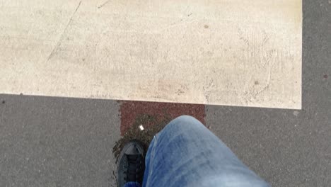 Walking-over-pedestrian-zebra-crossing-on-a-rainy-day,-pov-shot