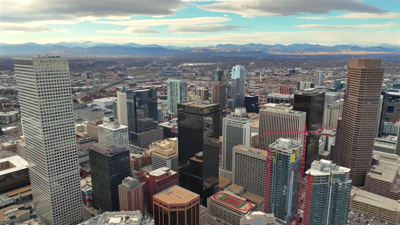 Skyline del centro di Denver, in Colorado, con gru, lavori di costruzione e le Montagne Rocciose sullo sfondo - Vista aerea con drone