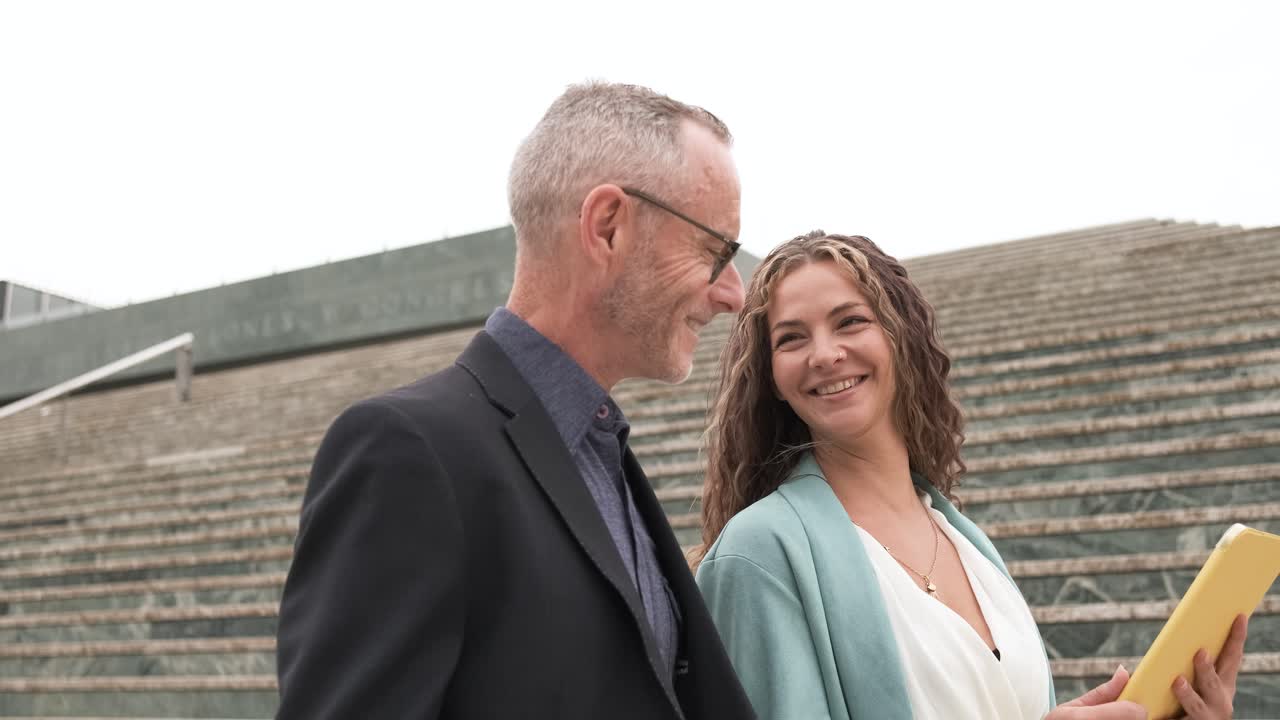 Business people discussing and using tablet near steps