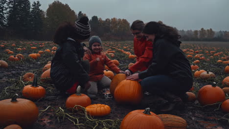 family enjoys a day of pumpkin picking at a muddy pumpkin patch in autumn