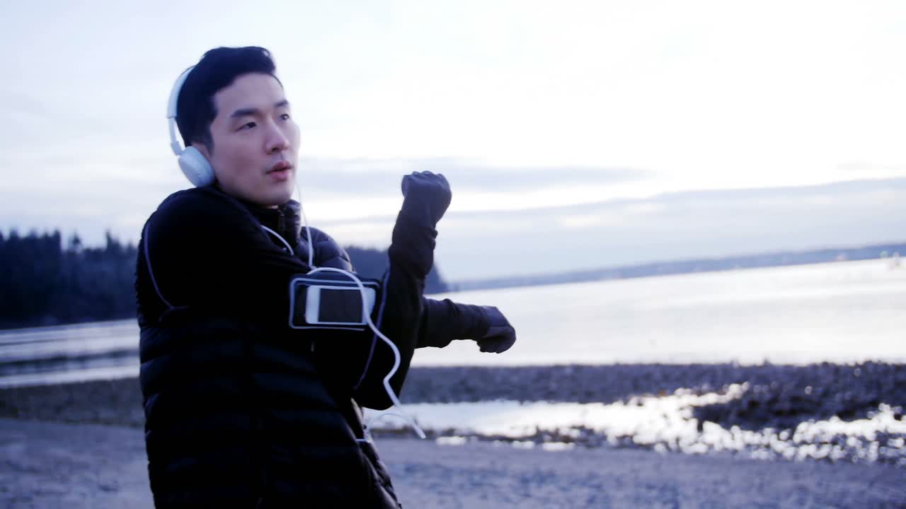 헤드폰 4k에서 음악을 들으면서 스트레칭 운동을 하는 남자