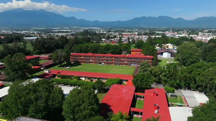 Campo de futebol, arquibancadas e edifícios do campus no Centro Regional de Educación em Ciudad Guzmán, Jalisco, México. - foto aérea