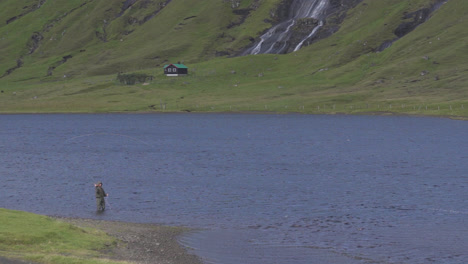 shot of a fisherman fishing in the fjords of the faroe islands