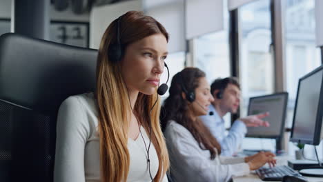 agente de servicio profesional habla con el cliente en auriculares. mujer enfocada escribiendo computadora