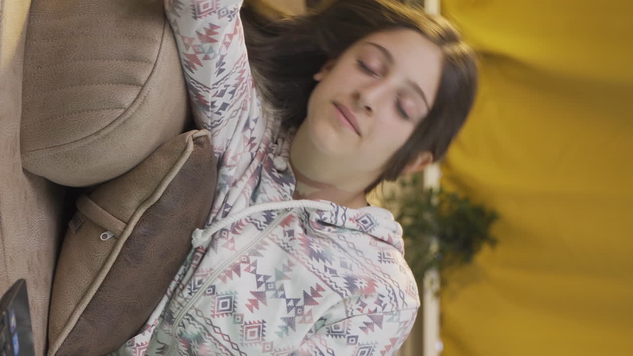 젊은 여성의 수직 비디오는 밤에 노트북에서 피곤하고 지쳤습니다.