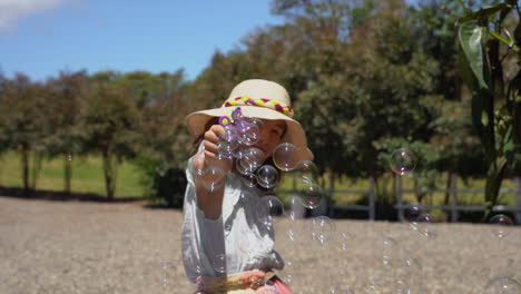 front portrait caucasian girl plarying bubble gun slow motion summer