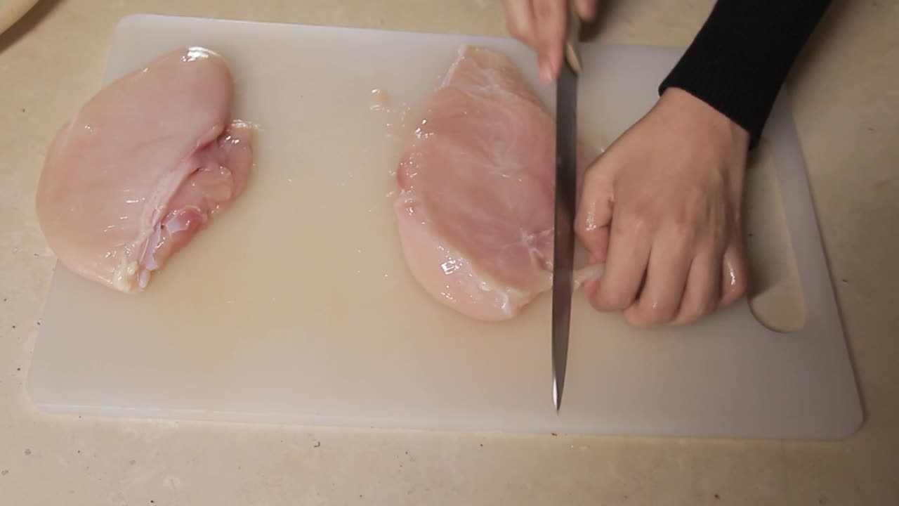vista dall'alto dello chef che taglia la carne di pollo sul tavolo della cucina