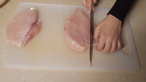 Blick-Von-Oben-Auf-Den-Küchenchef,-Der-Hühnerfleisch-Auf-Dem-Küchentisch-Schneidet