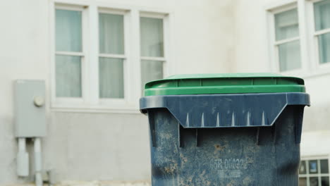 el propietario tira la basura doméstica en un contenedor cerca de la casa 04