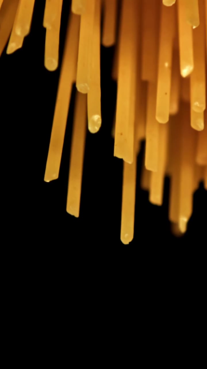 Primo piano astratto di fili di spaghetti secchi su sfondo nero