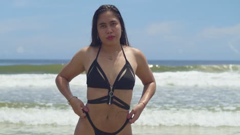 en la costa tropical, una belleza latina muestra su cabello largo y estilo en un traje de baño de tanga