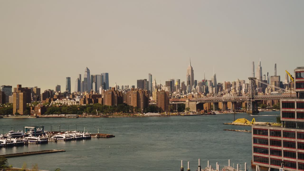 Panorama wide shot of docking boats at port with Skyline in background - New York City,US