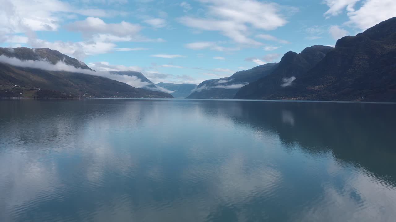 Serene Norwegian fjord with stunning reflection and mountains in the distance