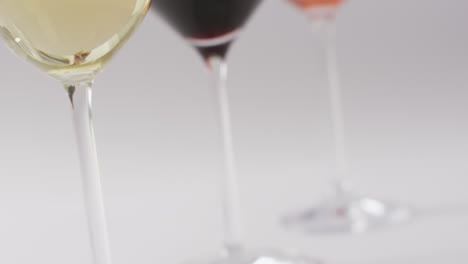 diverse types of wines in glasses on white surface with copy space