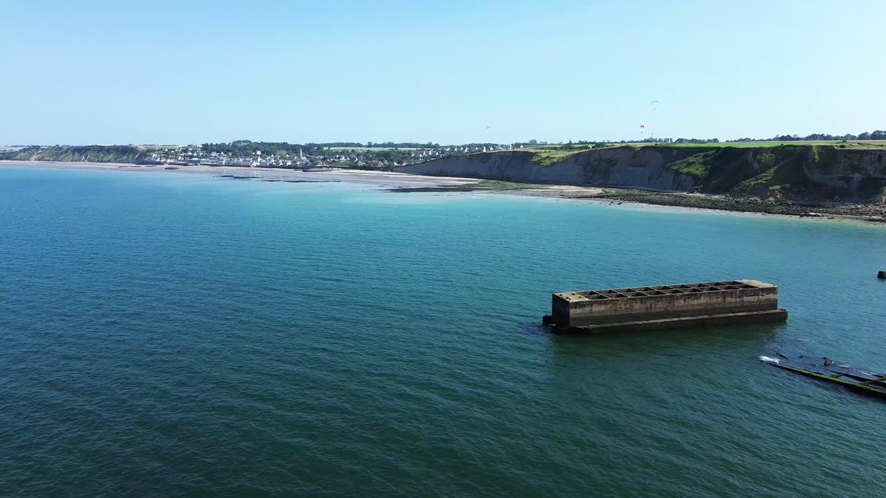 Aerial drone shot capturing the WWII Mulberry harbour remains at Arromanches