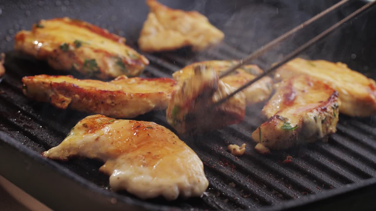 Cooking raw chicken meat in yellow turmeric spice with garlic and greens on grill close-up. Fry chicken slice on frying.pan Grilled chicken, duck, turkey kebab with vegetables.
