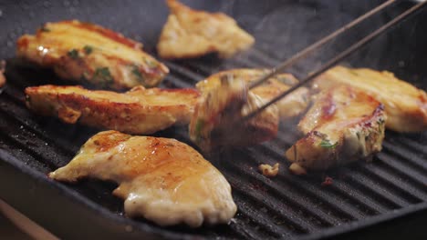 cooking raw chicken meat in yellow turmeric spice with garlic and greens on grill close-up. fry chicken slice on frying.pan grilled chicken, duck, turkey kebab with vegetables.