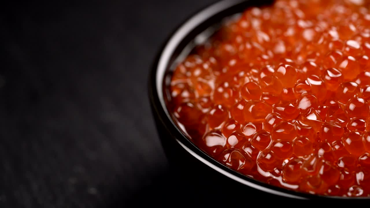 Caviar Vermelho Girando sobre Fundo Preto