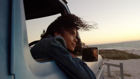 woman leaning on window of pickup truck at beach 4k