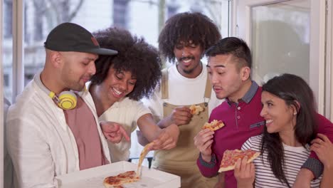 diverse group of friends sharing and eating pizza together