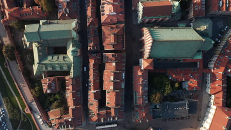 Los-Pájaros-Aéreos-Miran-Desde-Arriba-Hacia-Abajo-La-Vista-Panorámica-De-Los-Tejados-De-Tejas-Rojas-Y-Las-Plazas-En-El-Centro-Histórico-Del-Casco-Antiguo.-Gente-Caminando-Y-Haciendo-Turismo.-Varsovia,-Polonia