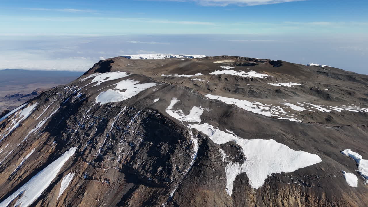 fotografía aérea del pico uhuru rodeado de formaciones glaciales en el kilimanjaro, fotografía de un dron giratorio