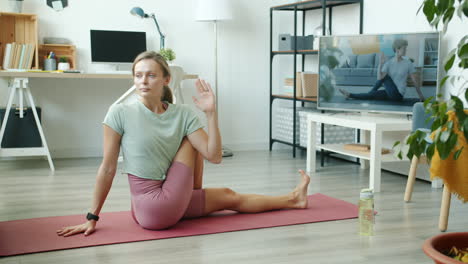 woman doing yoga at home with online tutorial