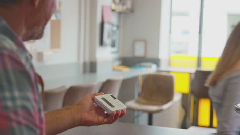 cliente femenino haciendo pago sin contacto para bebida para llevar en una cafetería usando tarjeta