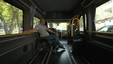 man in wheelchair in the special the vehicle. the disabled person is transported in a special car. transportation of disabled people in a special car, bus.