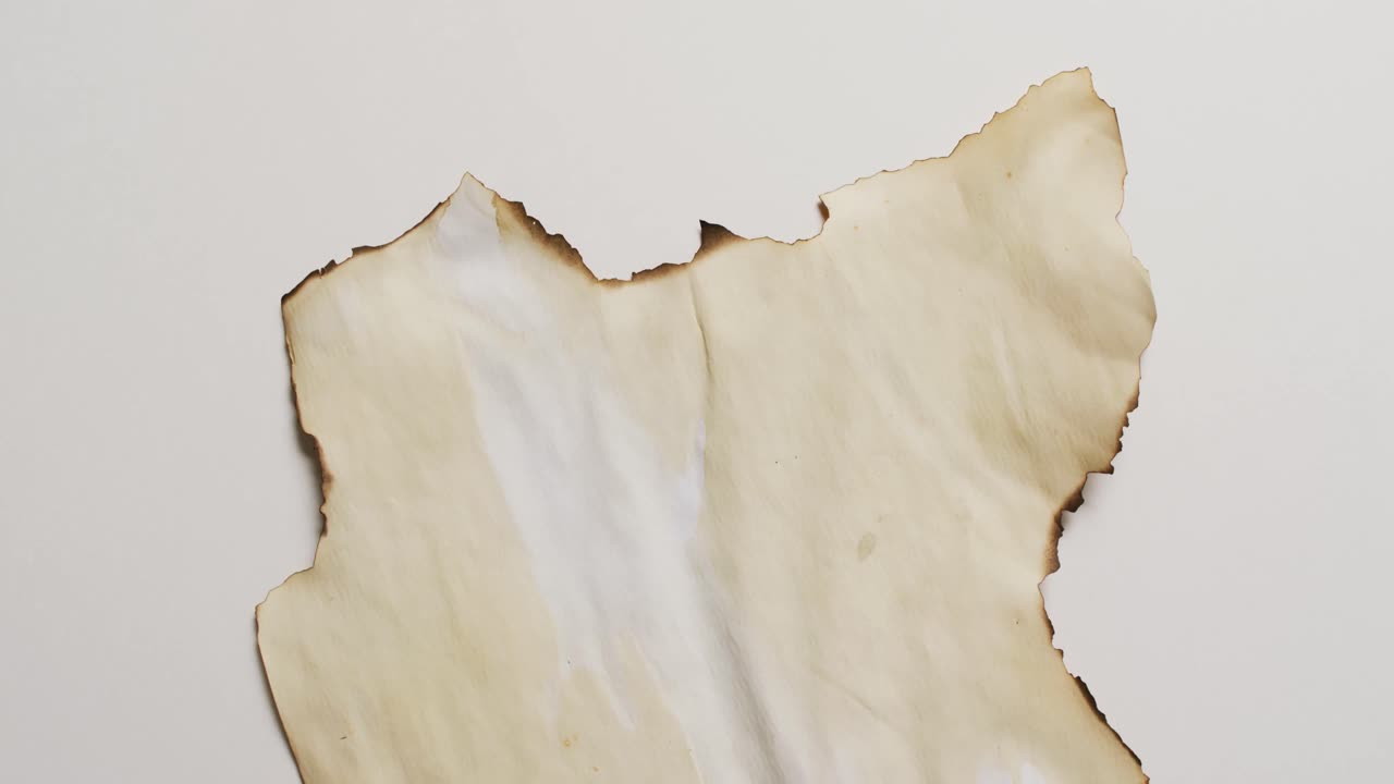 ⁇  배경 에 불타진 가장자리 를 가진 종이 조각 의 클로즈업 영상