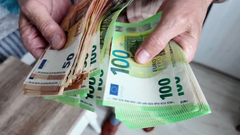 senior man counting savings in euro banknotes, finances, savings and people concept