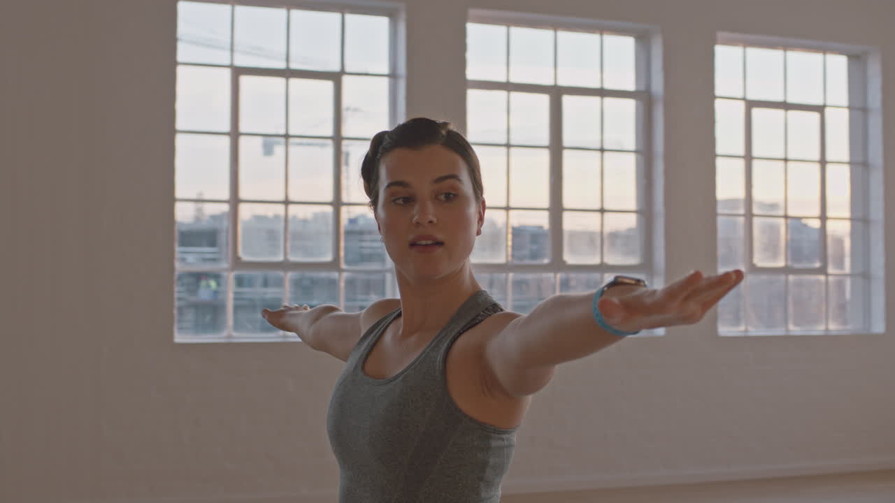 clase de yoga de mujeres embarazadas sanas practicando pose guerrera disfrutando de ejercicios físicos grupales con instructor en el estudio al amanecer