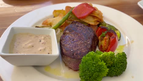 Filete-De-Solomillo-Jugoso-Con-Salsa-De-Pimienta,-Verduras-Y-Patatas-En-Un-Restaurante,-Carne-De-Vacuno-De-Alta-Calidad,-Tiro-De-4k