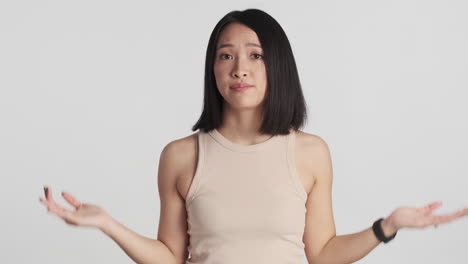 Asian woman showing I don&acute;t know expression on camera.