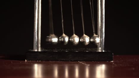 newton's cradle over black background front view close shot