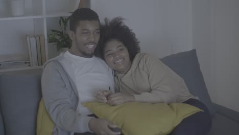 young african american couple having fun while watching tv in the dark