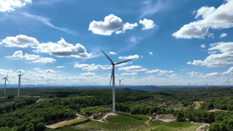 cinematic backward view of wind turbines rotating at