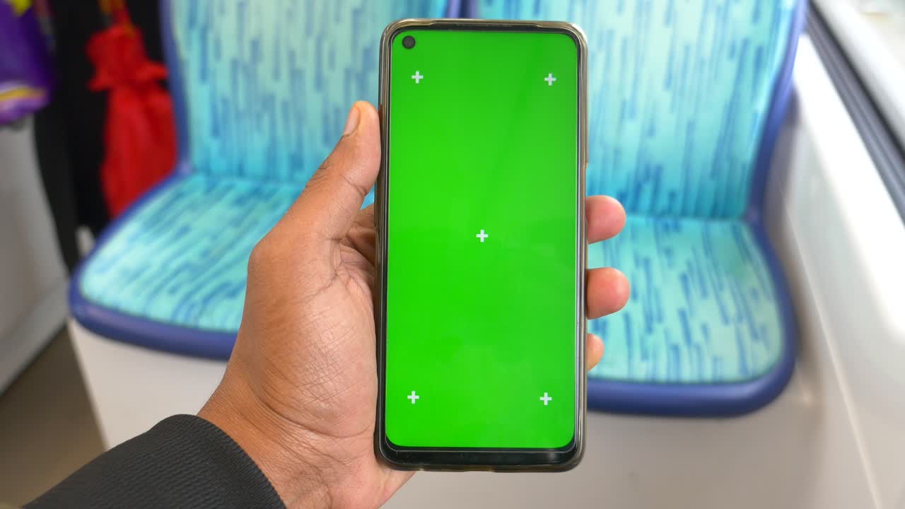 una persona con un teléfono de pantalla verde en un autobús