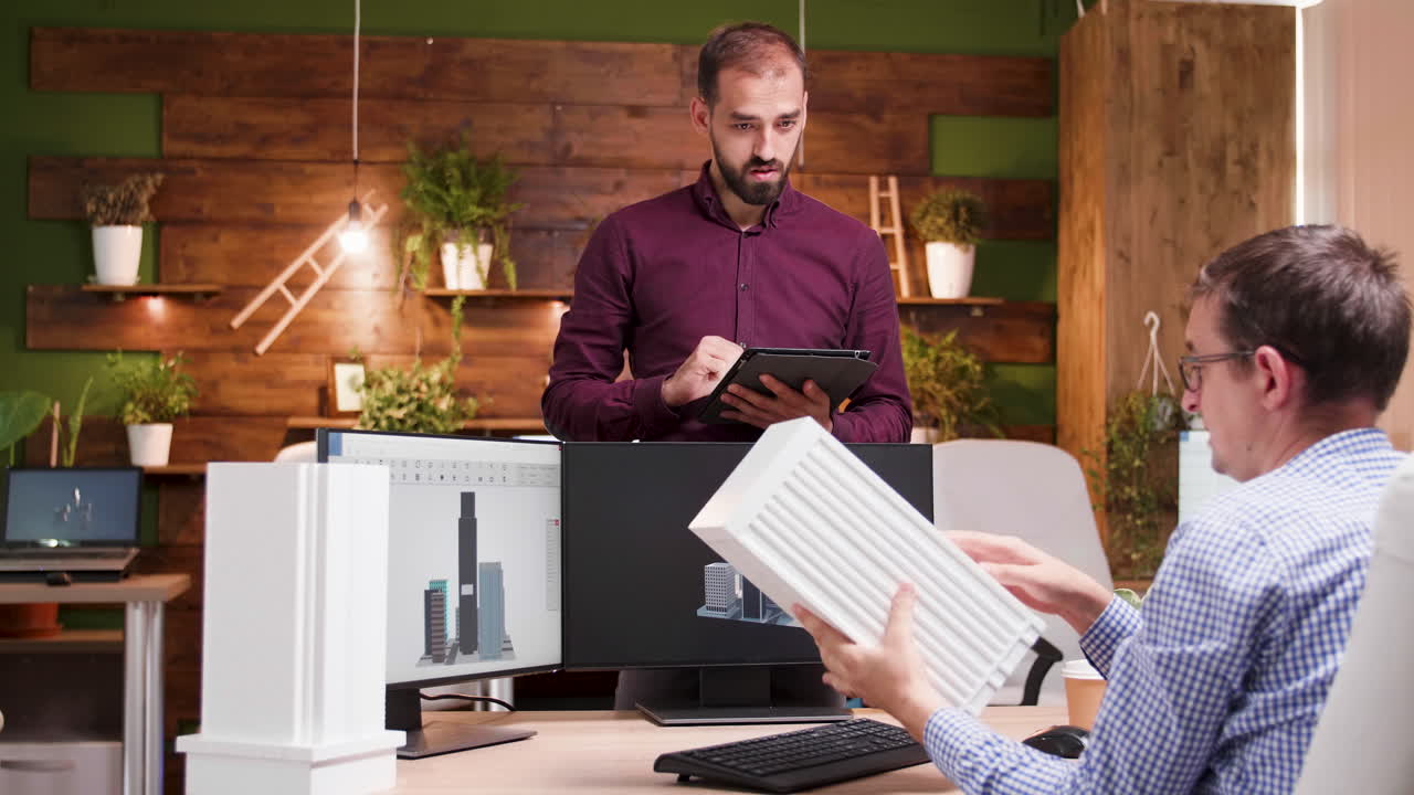Two men working on architectural designs in an office setting