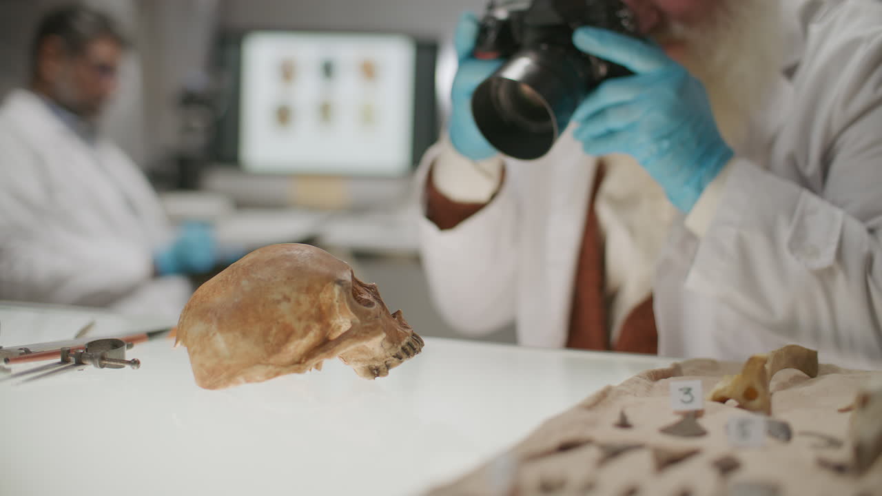 Archaeologist Photographing Ancient Skull on Research Table in Laboratory