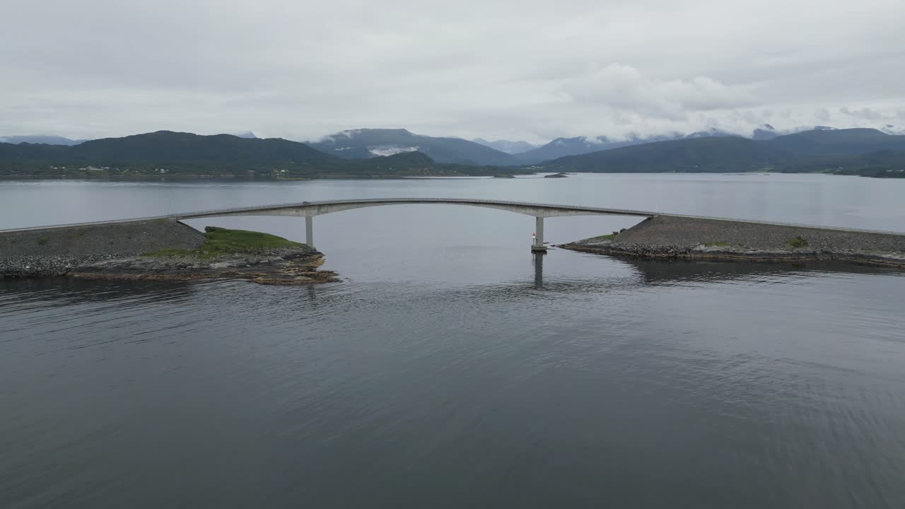 바다 한가운데 두 섬을 연결하는 다리를 지나가는 자동차와 함께 노르웨이의 대서양 도로 atlanterhavsveien을 향해 비행