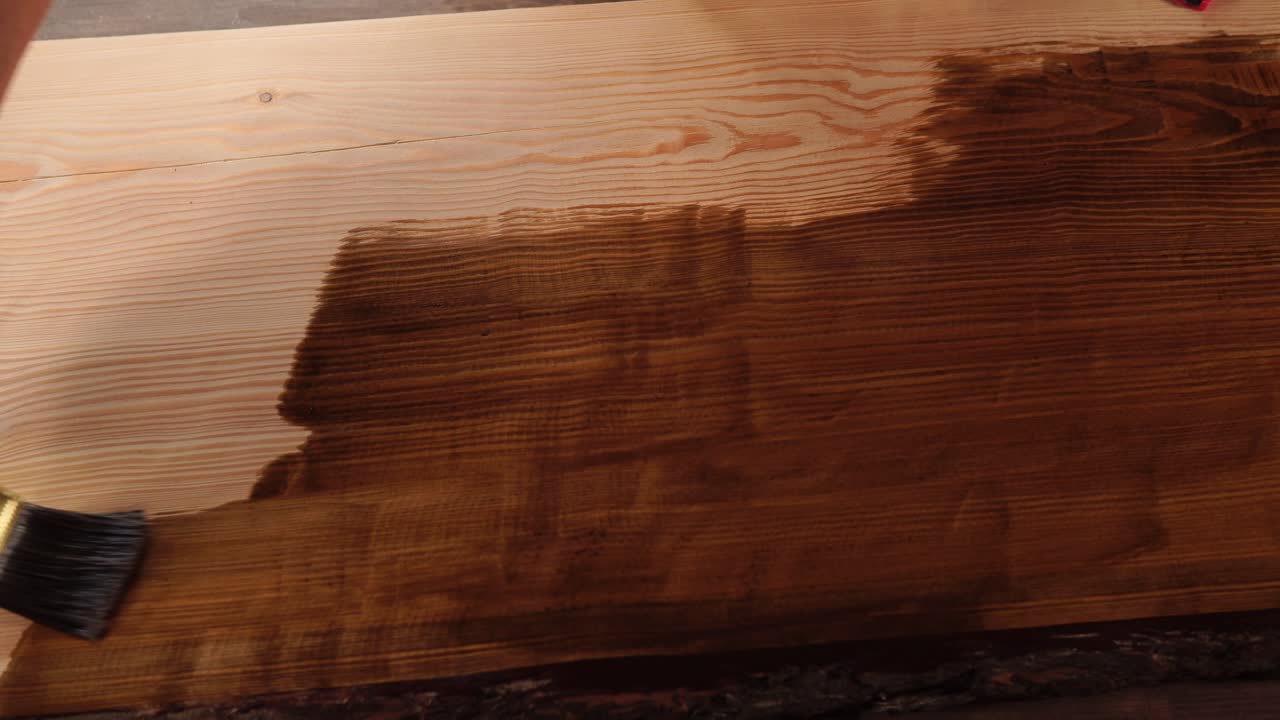 la aplicación de la mancha de madera a una tabla