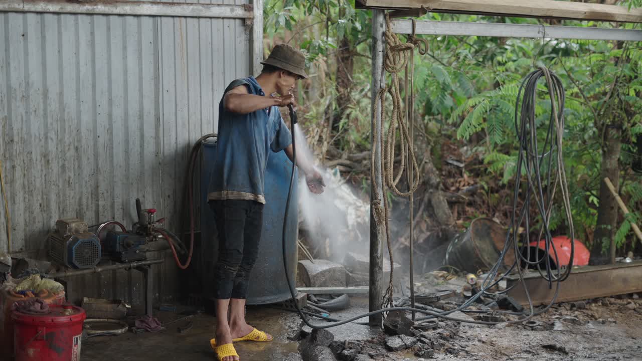 Man cleaning equipment in a workshop