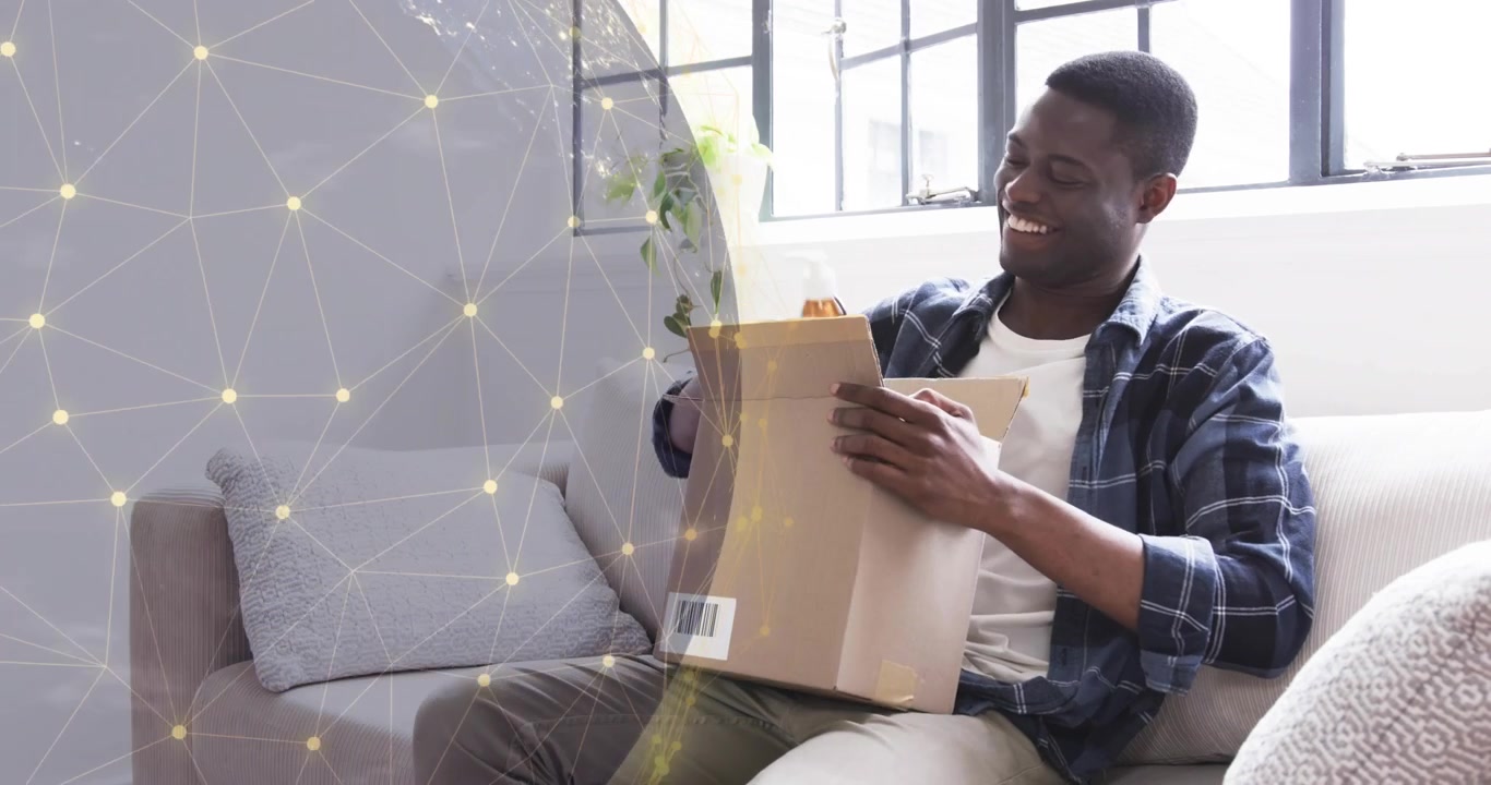 Man opening box on grey sofa and extracting brown bottle and pump container for e-commerce review