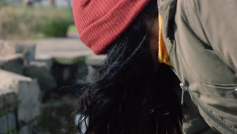 Cerrar-Una-Mujer-Joven-Salpicando-La-Mano-En-El-Agua-Tocando-Juguetonamente-Un-Estanque-Fresco-En-Un-Parque-Natural-Al-Aire-Libre