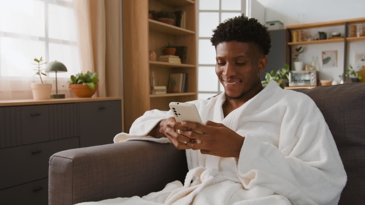 Man in Robe Using Phone at Home