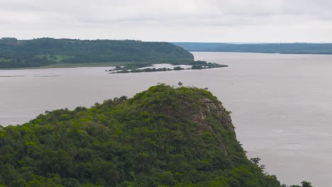 Panoramablick-Auf-Mit-üppigem-Dschungel-Geschmückte-Berge,-Während-Im-Hintergrund-Ein-Imposanter-Fluss-Majestätisch-Fließt